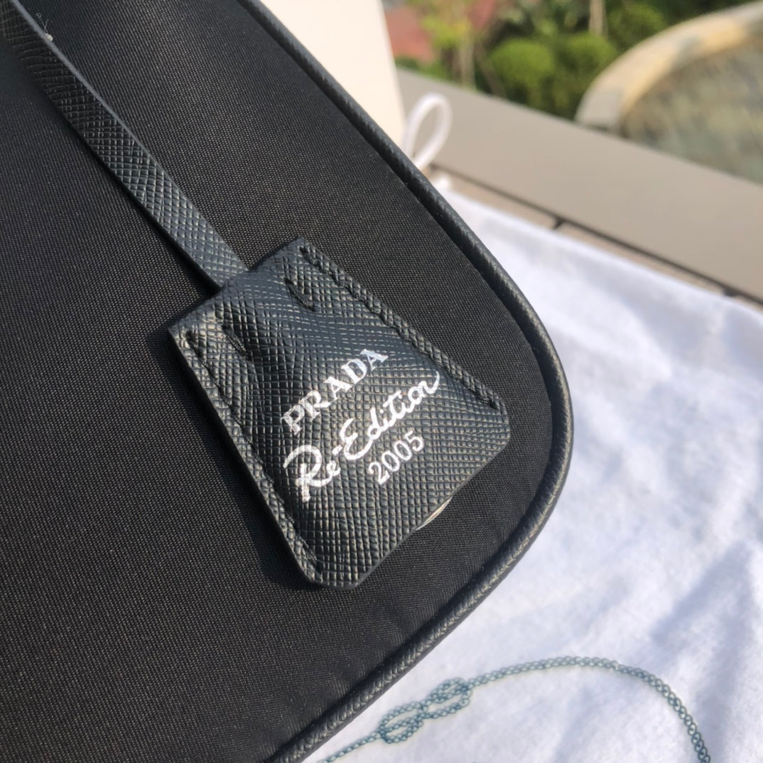 尺寸：22×18×6.5cm（55880898） 代工廠出品PRADA Re- Edition尼龍手袋❗️現貨供應！此款Prada2005系列的標誌性風格，綻現柔美設計與現代細節。尼龍由Prada率先引入時尚界，是品牌標誌性的材質。 Saffiano皮革細節可拆卸鏈條，可拆卸可調式標誌印花編織尼龍肩帶➕可拆卸尼龍小袋，配拉鍊和Re-edition鑰匙扣金屬配件，設計別出心裁
