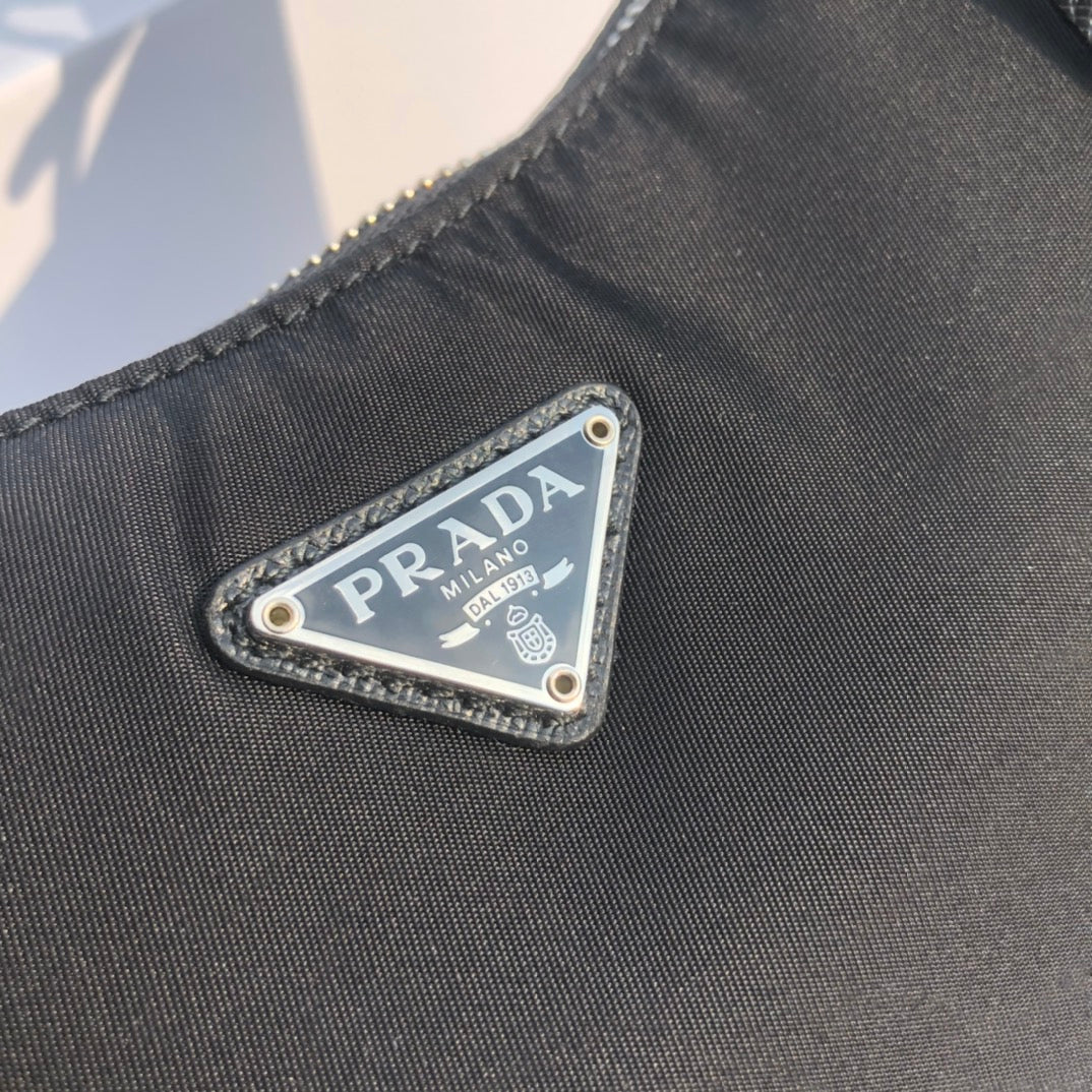尺寸：22×18×6.5cm（55880898） 代工廠出品PRADA Re- Edition尼龍手袋❗️現貨供應！此款Prada2005系列的標誌性風格，綻現柔美設計與現代細節。尼龍由Prada率先引入時尚界，是品牌標誌性的材質。 Saffiano皮革細節可拆卸鏈條，可拆卸可調式標誌印花編織尼龍肩帶➕可拆卸尼龍小袋，配拉鍊和Re-edition鑰匙扣金屬配件，設計別出心裁