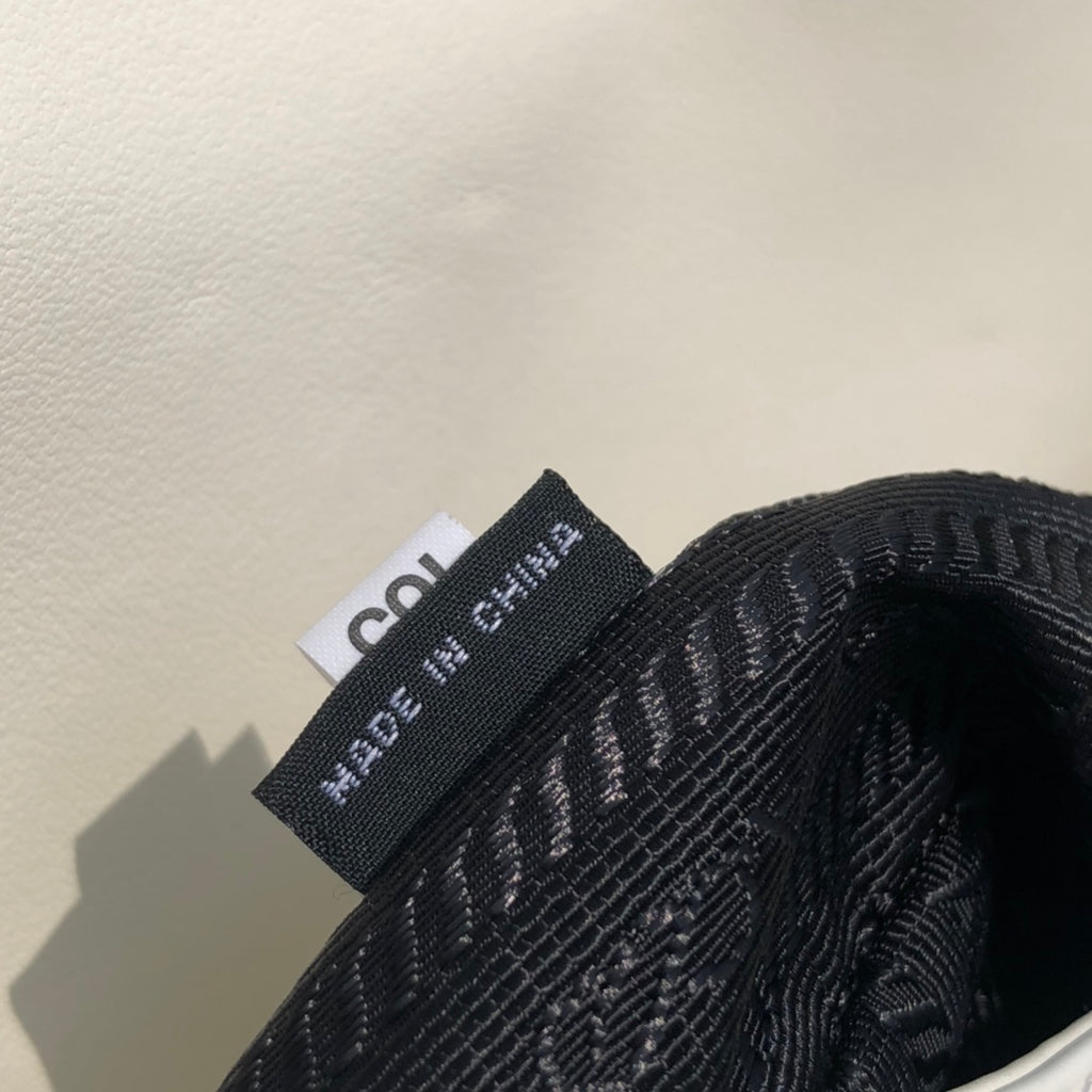 白色❗️尺寸：19*6*24cm（56980898）PRADA代工廠出品翻蓋腋下包❗️普拉達這款精緻的Prada Cleo手袋重新詮釋品牌標誌性的復古設計。底部和側面獨特的傾斜結構彰顯這款翻蓋手袋簡約的弧形線條，賦予其輕盈柔和的造型風格。 Prada系列別緻的亮面皮革材質頗具現代感與多變風格，慣於創造嶄新的組合與對比效果。琺瑯三角形標誌呈現鮮明的品牌格調。磁扣扣合Prada標誌尼龍襯裡，配上貼布口袋。可延長皮革提把，可將單肩包變成斜背包！