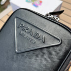 尺寸:19×16×5.5cm（581150898） PRADA通路資源特供訂單❗️Saffiano皮革壓花標誌手機包，採用普拉達標誌性的Saffiano 皮革，呈現別緻的交叉平行線陰影紋理和塗蠟飾面。 Prada 富有像徵意義的三角形標誌化身大幅壓花細節鋪陳於正面。背面塗琺瑯金屬三角形標誌，拉鍊開合，RE-Nylon 再生尼龍襯裡，可拆卸調價刺繡織帶肩帶
