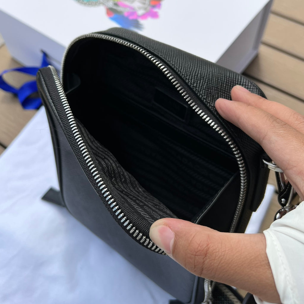 尺寸:19×16×5.5cm（581150898） PRADA通路資源特供訂單❗️Saffiano皮革壓花標誌手機包，採用普拉達標誌性的Saffiano 皮革，呈現別緻的交叉平行線陰影紋理和塗蠟飾面。 Prada 富有像徵意義的三角形標誌化身大幅壓花細節鋪陳於正面。背面塗琺瑯金屬三角形標誌，拉鍊開合，RE-Nylon 再生尼龍襯裡，可拆卸調價刺繡織帶肩帶