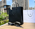 尺寸:37×35×7cm（111450898） PRADA通路資源特供訂單❗️男士托特包，這款時尚簡約的托特包取材品牌標誌性的Saffiano 皮革，呈現別緻的交叉平行線陰影紋理和塗蠟飾面。 Prada 富有像徵意義的三角形標誌化身大幅壓花細節，re-Nylon 再生尼龍襯裡，可拆卸調整刺繡織帶、皮革手柄！風格中性實用，整體設計簡約大方，搭配商務穿搭更有質感