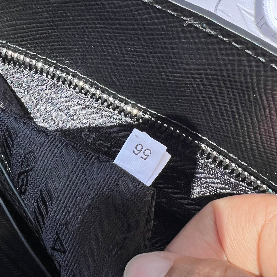尺寸:37×35×7cm（111450898） PRADA通路資源特供訂單❗️男士托特包，這款時尚簡約的托特包取材品牌標誌性的Saffiano 皮革，呈現別緻的交叉平行線陰影紋理和塗蠟飾面。 Prada 富有像徵意義的三角形標誌化身大幅壓花細節，re-Nylon 再生尼龍襯裡，可拆卸調整刺繡織帶、皮革手柄！風格中性實用，整體設計簡約大方，搭配商務穿搭更有質感