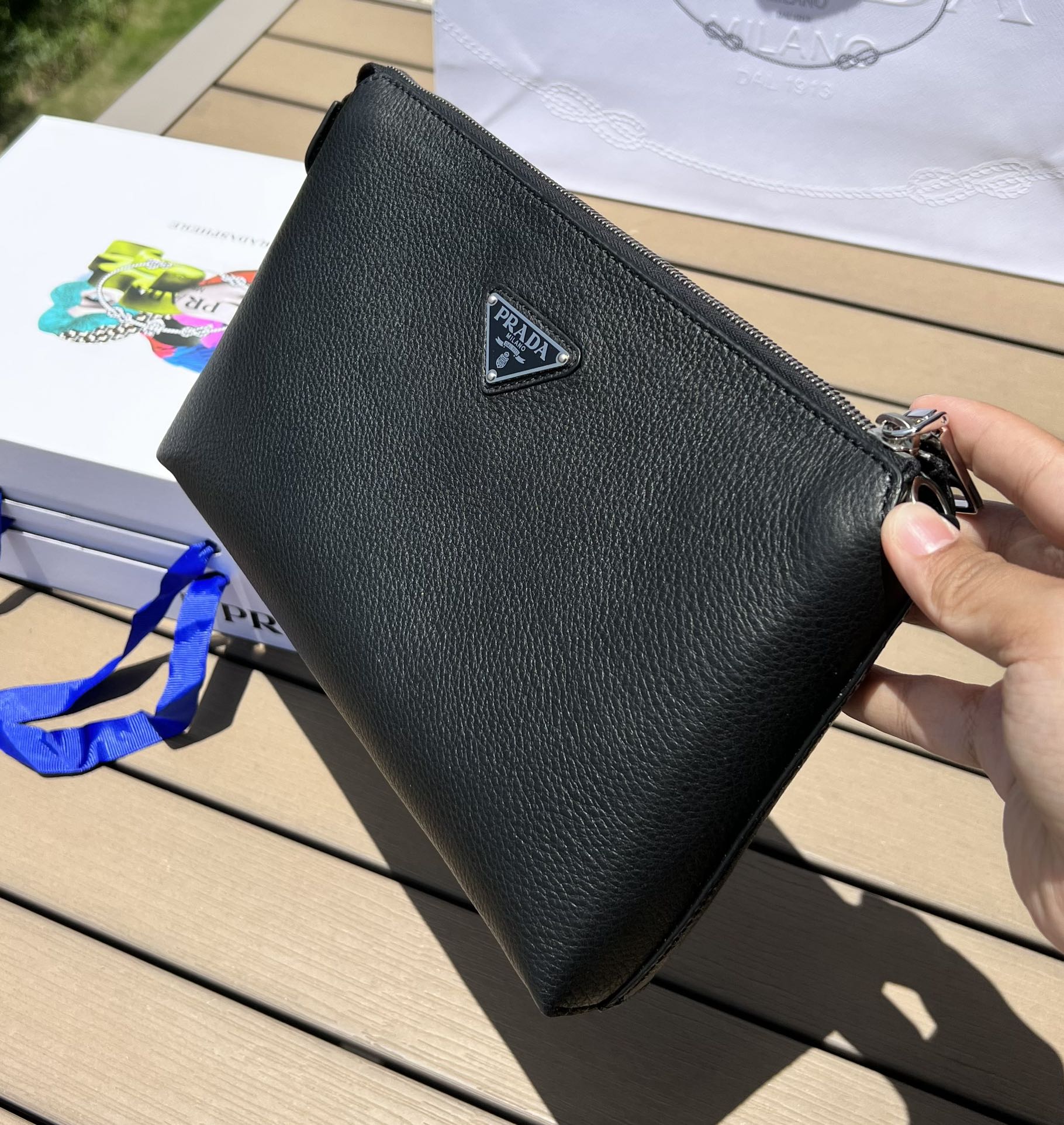 尺寸:28×18×3cm（05680898） PRADA通路資源特供手拿包❗️原廠特供荔枝紋，難得純原好東西，荔枝紋手拿包配有拉鍊和可拆卸腕帶，正面飾以三角形徽標，後面logo壓印。彰顯品牌格調。內裡配有拉鍊隔代，容量夠大，日常通勤足夠使用了