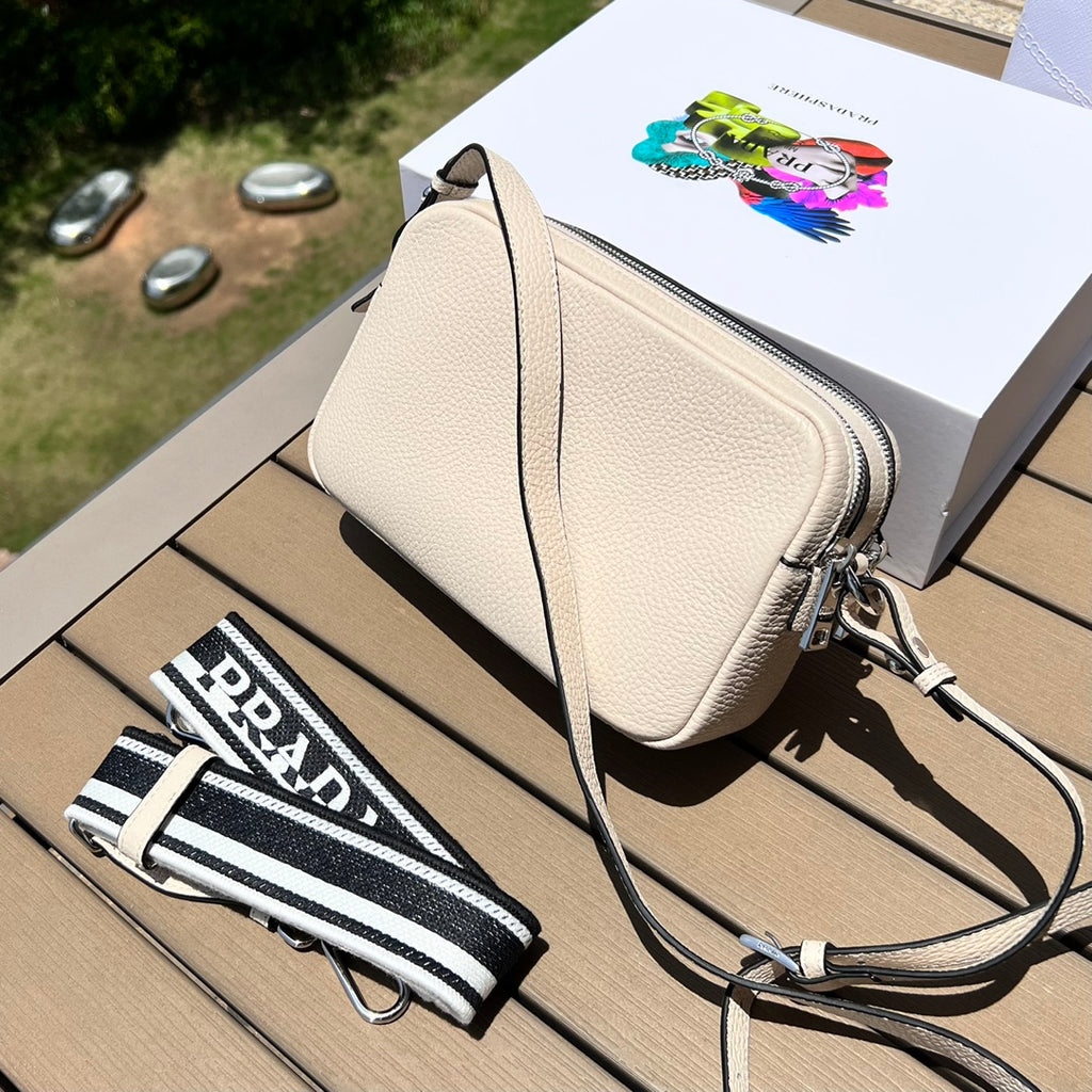 尺寸:22×14.5×8.5cm（581180898） PRADA通路資源特供皮革相機包❗️Prada 相機包男女同款相機包實在太可愛了。對小個子來說簡直是福音，容量超大有兩個隔層，通常出街就夠使用了。附雙肩帶，能背也能提，凹造型也不錯！